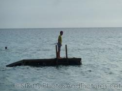 Person standing on a floating platform in the waters off of the Shipwreck Bar & Grill in St Kitts.jpg