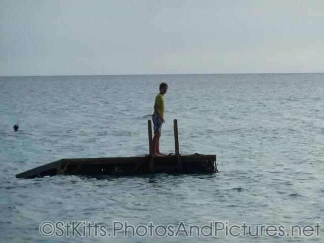 Person standing on a floating platform in the waters off of the Shipwreck Bar & Grill in St Kitts.jpg
