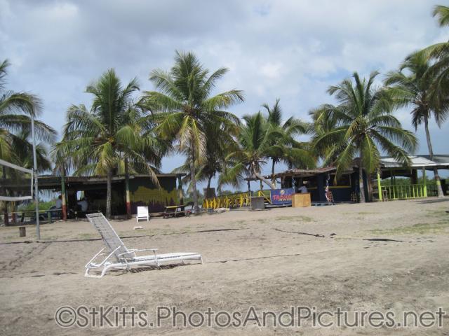 Palm trees and bars at Monkey Bar Beach in St Kitts.jpg