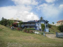 Blue apartment structure with Canadian flag in St Kitts.jpg